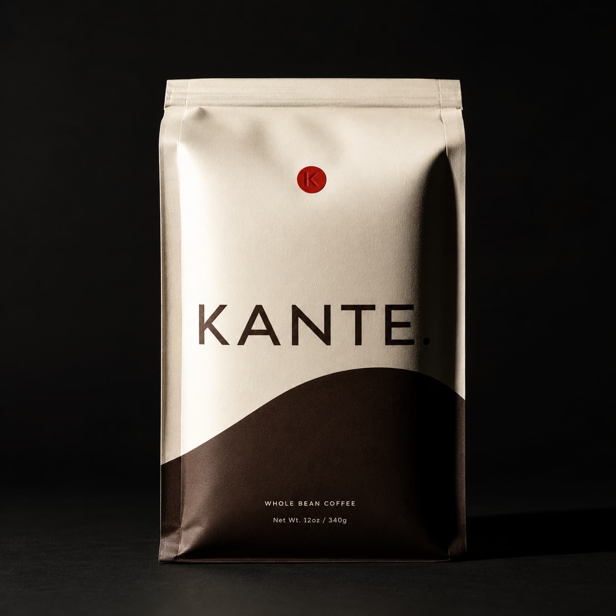 KANTE. Coffee Bag, frontal, hartes Studiolicht, Warmschwarz-Hintergrund.